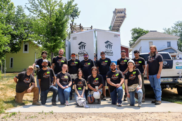 Design Engineers day two volunteers standing in front of the Habitat for Humanity trailer.