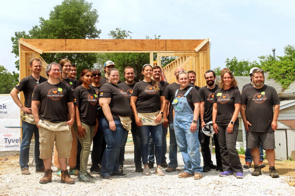 Design Engineers 40th anniversary volunteer group in Cedar Rapids standing in front of the partially built house.