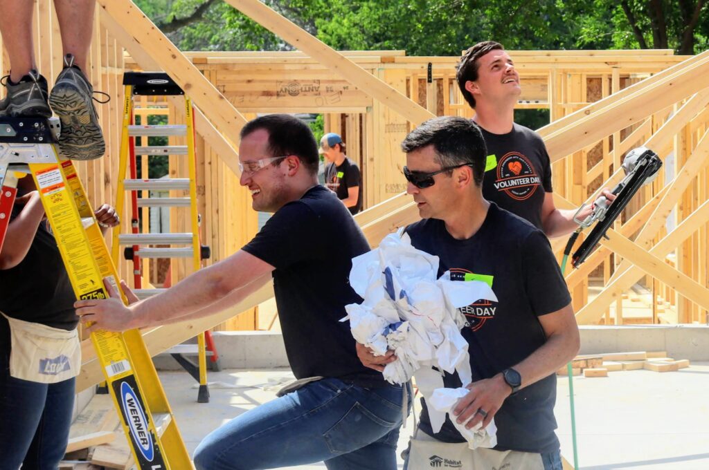 From left to right: Ryan, Justin, and Trevor volunteering on the Habitat for Humanity job site.