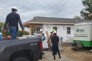 The Engineers Madison team unloading a pickup truck in front of the Habitat for Humanity of Dane County house. 