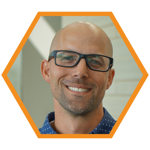 Headshot of Associate Principal Eric Bruxvoort in an orange hexagon frame.